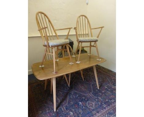 An Ercol light elm dining table and four (2+2) Ercol high hooped spindle back dining chairs. 