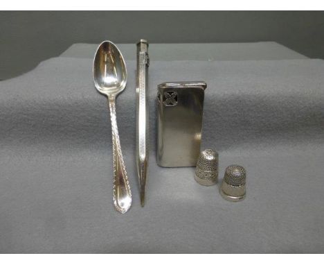A silver cigarette lighter, maker B.B.S. Ltd, Glasgow 1934, a silver propelling pencil, two silver thimbles and a silver teas
