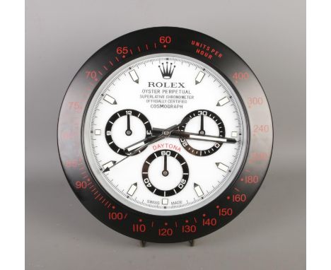 A Rolex style dealer display concessionary wall clock, "Daytona" black bezel surround with white dial.  Quartz movement, work