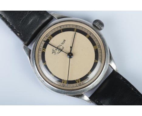 A Gents Hamilton manual wind wristwatch, with 23 jewel movement and baton markers to the beige and black ring dial. Featuring