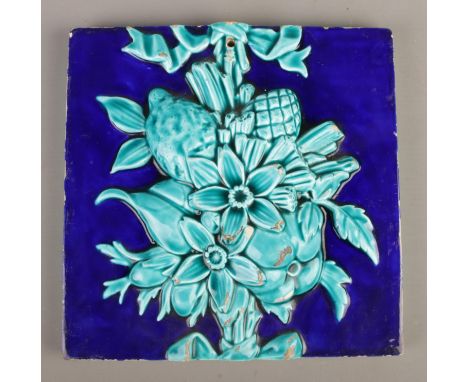 A large Mintons deep blue and turquoise tile with raised floral and fruit decoration. Stamped Mintons and 1125 to the reverse