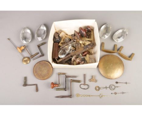 A box of assorted fixtures and fittings, mainly clock parts. To include winding handles and keys, glass droplets, fingers and