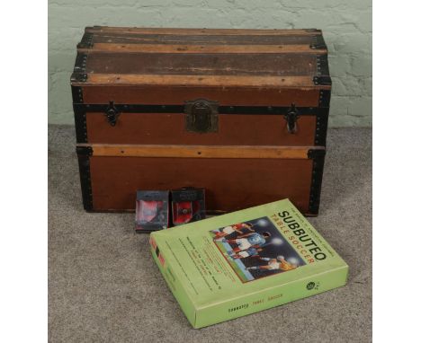 A vintage dome top steamer trunk with two Star Wars figures of tie fighters and a Subbuteo table top soccer game