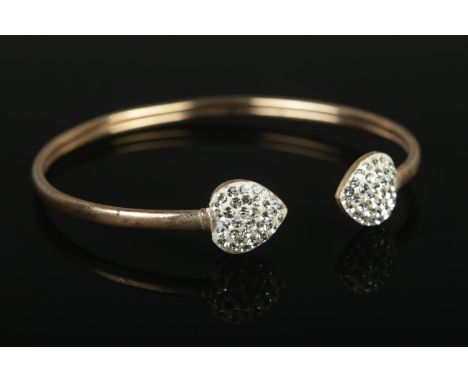 A 9ct Gold bangle, with paste set heart shaped terminals. Total weight: 3.2g.