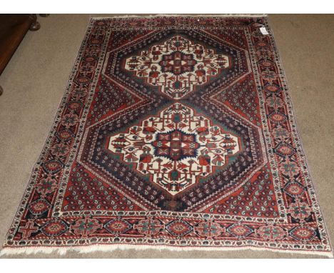 Afshar Rug South East Iran, 20th century The madder field with twin ivory medallions framed by stylised flowerhead borders, 1