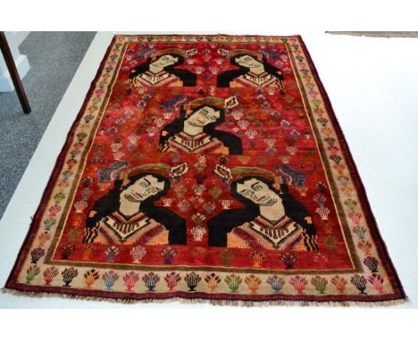 Kashgai Rug South West Iran The blood red field with five portraits of a lady enclosed by ivory borders, 232cm by 154cm Ends 