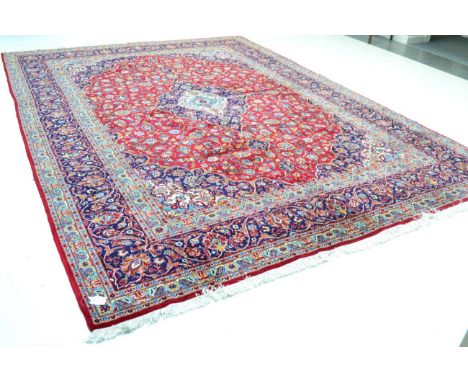 Kashan design carpet, circa 1960, possibly machine madeThe raspberry field with ivory and indigo central medallion framed by 