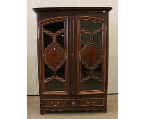 An Early 19th Century French Oak Armoire, adapted with glazed doors enclosing an adjustable shelf, the base with a long drawe