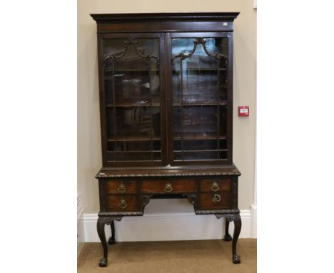 A Carved Mahogany Chippendale Revival Cabinet on Stand, late 19th century, the Greek Key dentil cornice above glazed doors en