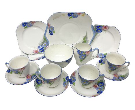 Shelley Strand shaped tea wares, decorated with blue and pink daisies upon a white ground, comprising four teacups, four sauc