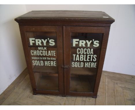 Early 20th C stained and grained pine two tier shelf cabinet enclosed by two glazed cupboard doors with later stenciled lette