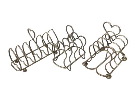 Three Edwardian silver toast racks.
