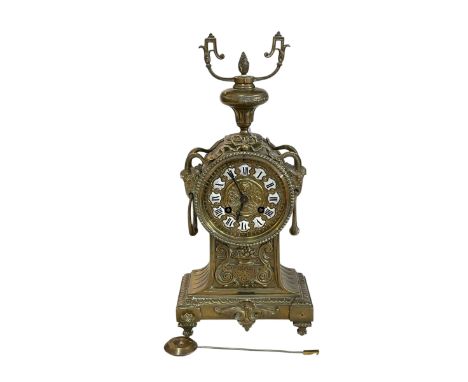 Ornate brass mantel clock with enamel Roman numerals.