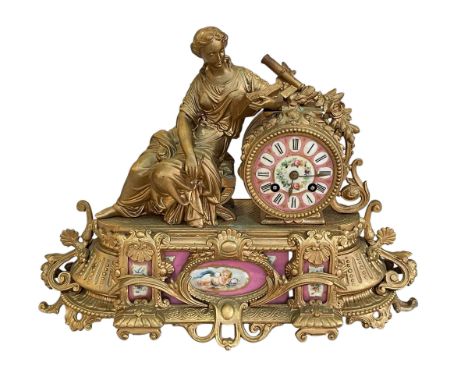 Ornate Continental gilt mantel clock decorated with pink porcelain panels and face.