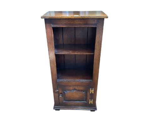 Titchmarsh & Goodwin oak bookcase, the open top with one shelf above an ogee shaped fielded panel door, 97cm by 46.5cm by 25.