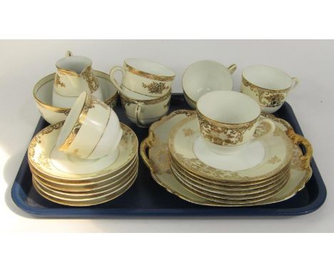 A Japanese porcelain part tea service, gilt decorated with baskets of flowers against an ivory ground, painted mark RC, compr