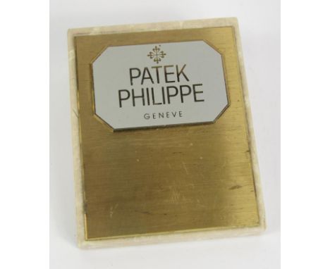 A Patek Philipe brass and marble advertising paperweight of wedge form, 12cm long.