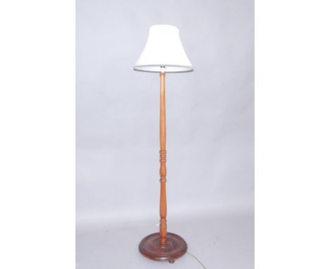 A turned oak standard lamp, raised on a circular base, 135cm high.