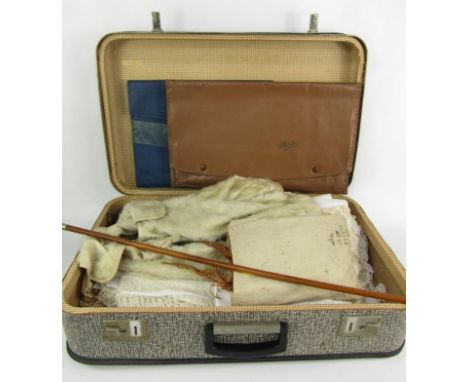 A suitcase of table linen and lace, child's jacket from E M Shepherd, Peterborough, swagger stick, pyjama and shirt cases.