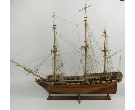 A wooden scale model of a three masted sailing ship, rigged without sails, on a stand, 74cm x 81cm.