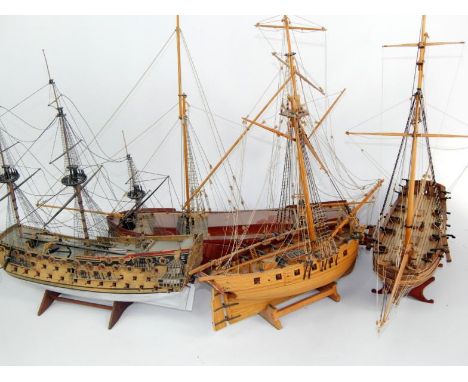 Two wooden scale models of armed ships, two masted sailing ship and a three masted galleon, three with stands. (4)