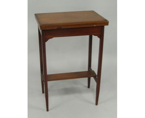 An Edwardian mahogany and boxwood line inlaid rectangular fold over card table, raised on tapering, square legs, united by st