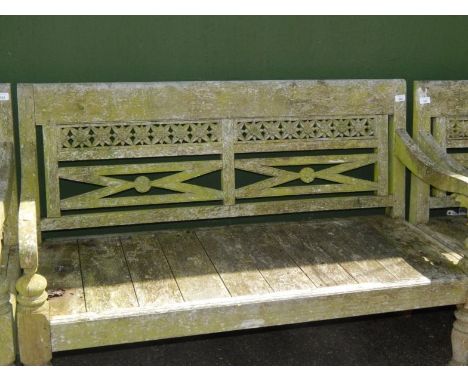 A two seater garden bench, with a pierced and carved foliate back, raised on turned legs, 131cm long.