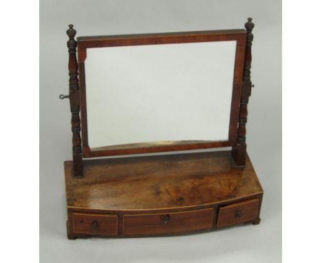 A George III mahogany and boxwood line inlaid bow fronted toilet mirror, the rectangular mirror within a baluster turned fram