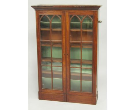 A George III mahogany wall mounted display cabinet, outswept pediment above two arched, glazed doors enclosing four shelves, 