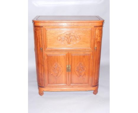 A Chinese bow fronted hardwood cocktail cabinet, the hinged top carved internally with birds and prunus blossom, opening to r