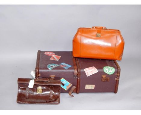 A brown canvas cabin trunk, bearing copy labels, 83cm long, and two leather attache cases, (3).