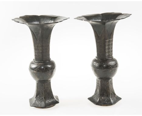 A PAIR OF EARLY 20th CENTURY CHINESE PATINATED BRONZE BEAKER VASES, with petal shaped flared rims above octagonal and bulbous