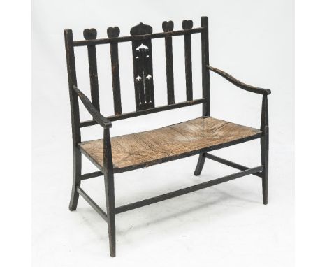 AN ARTS & CRAFTS PAINTED PINE RUSH SEATED BENCH IN THE STYLE OF CHARLES RENNIE MACKINTOSH, the heart carved crest rail over s