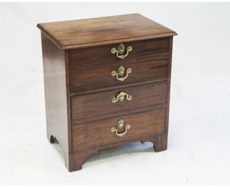 AN EARLY 19th CENTURY MAHOGANY BEDSIDE COMMODE CUPBOARD, the moulded rectangular top over four graduated cock beaded dummy dr