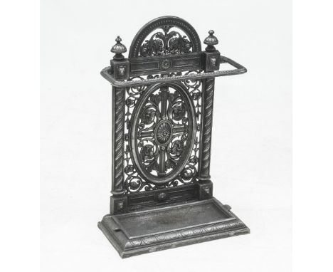 A VICTORIAN CAST IRON STICK/UMBRELLA STAND, the pediment flanked by finials over a rope twist cast rail raised on a lunette c