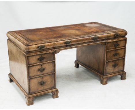A EARLY 18th CENTURY STYLE WALNUT TWIN PEDESTAL DESK, c. 1920, the moulded rectangular leather inset 'caddy' form top with th
