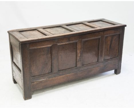 AN 18th CENTURY OAK FOUR PANEL COFFER, the moulded rectangular top over a panelled carcass, the stiles continuing to feet. 0.