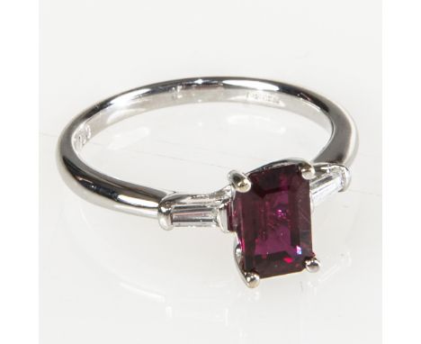 A RUBY AND DIAMOND RING, the emerald-cut ruby claw-set between diamond set shoulders, on an 18ct white gold band, ruby approx