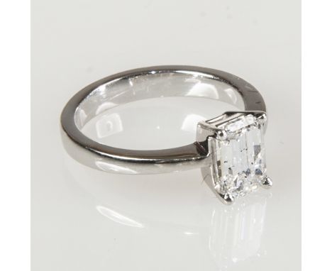 A DIAMOND SOLITAIRE RING, the emerald cut stone weighing 1.74 carats, claw set on a tapering 18ct white gold band, sold with 