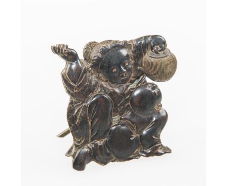 A 19th CENTURY ORIENTAL BRONZE MENU HOLDER with a mother holding a lantern and crouching down over her child, with hinged cro
