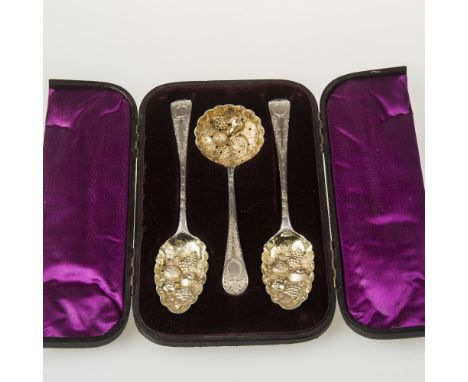 A CASED SET OF THREE SILVER AND GILT BERRY SPOONS, the two serving spoons and sifting ladle each with George III marks but la