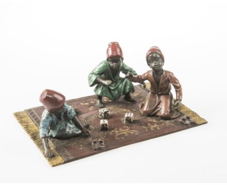 AN AUSTRIAN COLD PAINTED BRONZE GROUP OF ARAB BOYS ON A CARPET PLAYING DICE, CIRCA 1900, the base stamped 'Austria' with inci