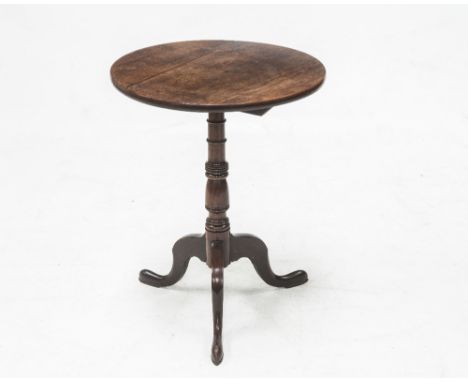 A GEORGE III MAHOGANY TILT TOP TRIPOD TABLE, the circular top above a turned baluster standard raised on down swept legs term