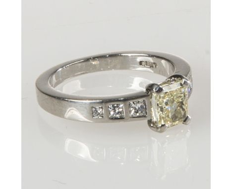 A STRIKING YELLOW DIAMOND RING, sold with GIA report, the cut-cornered rectangular modified brilliant cut stone weighing 1.03