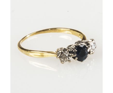 A SAPPHIRE AND DIAMOND THREE STONE RING, the round-cut sapphire flanked by a pair of round brilliant cut diamonds, all claw s