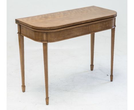 A SATINWOOD FOLD OVER CARD TABLE IN THE GEORGIAN TASTE, the rectangular top with rounded corners above a plain frieze raised 