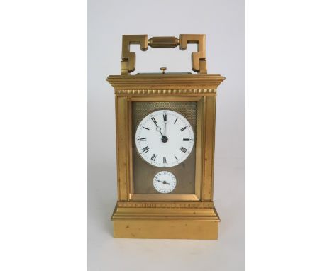 A FRENCH BRASS AND GLASS REPEATER CARRIAGE CLOCK the enamel dial with Roman numerals, with subsidiary alarm dial surrounded b