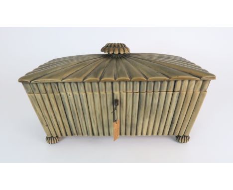 AN ANGLO INDIAN BUFFALO HORN TEA CADDY the hinged cover with floral finial, enclosing two angular ebony mounted hinged covers