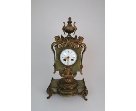 A FRENCH ONYX AND ORMOLU MOUNTED MANTLE CLOCK the enamelled dial with Roman numerals and swags of flowers with urn finial and