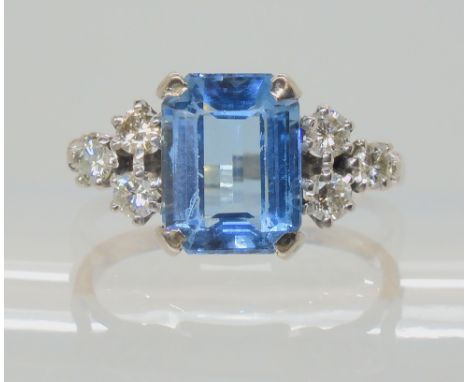 AN 18CT WHITE GOLD AQUAMARINE AND DIAMOND RING the emerald cut aquamarine measures approx 9.9mm x 7.7mm x 4.7mm, with trios o